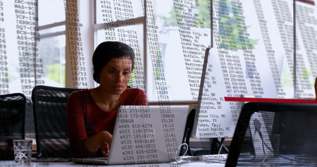 Image of financial data processing over biracial businesswoman using laptop in office. Global...