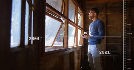 Image of financial data processing over caucasian man taking notes and looking through window....