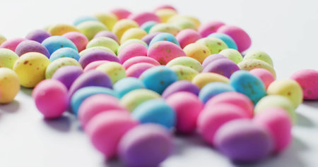 Image of happy easter text over colourful eggs on white background. Easter, tradition and celebration concept digitally generated image.の写真素材