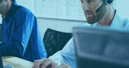 Image of data on graph processing over caucasian businessman wearing headset using computer....