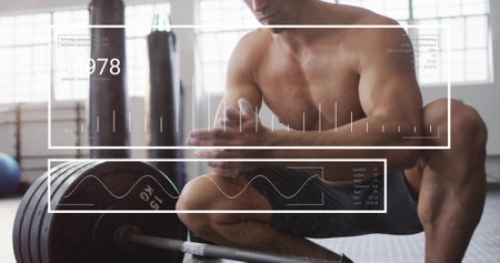 Image of diagrams and data processing over caucasian strongman at gym. Global technology, sport and digital interface concept digitally generated image.の写真素材