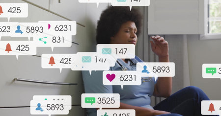 Image of social media icons with growing numbers over african american female doctor. Global social media, communication and digital interface concept digitally generated image.の写真素材