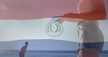 Paraguay flag image over people enjoying beach activities. summer, sand, ocean, swimming, sunbathing, leisureの写真素材