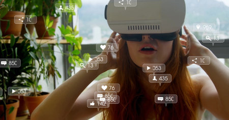 Wearing VR headset, woman surrounded by social media notifications image. Virtual reality,...