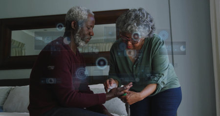 Image of data processing over senior african american couple cleaning hand. Lifestyle, computing and digital interface concept digitally generated image.の写真素材