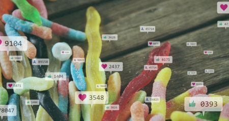 Colorful gummy worms with social media likes and comments image over them. Candy, sweets, digital,...