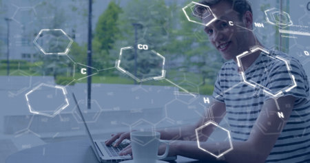 Image of elements and data processing over happy caucasian male student using laptop in cafe. Chemistry, science, data, digital interface, education and learning, digitallyの写真素材