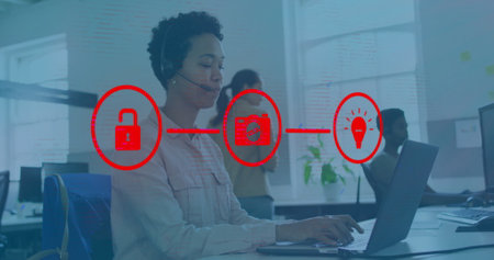 Image of network of connections with icons over biracial businesswoman working in office....