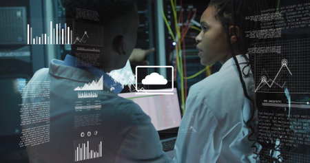Image of data processing and diagrams over biracial workers using laptop in server room. Technology...