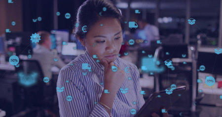 Image of network of connections with icons over biracial businesswoman using tablet in office....