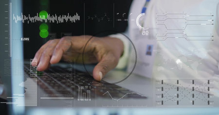 Image of data processing over african american businessman using laptop. Global technology, communication, computing and digital interface concept digitally generated image.の写真素材