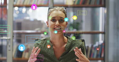 Image of media icons over caucasian businesswoman having image call. Business, technology and...