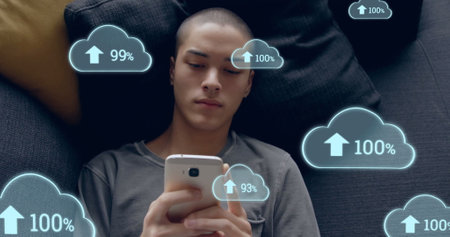 Image of cloud icons over biracial man using smartphone. Technology, social media and digital...