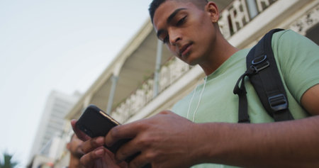 Close up of biracial man using smartphone in the street. backpacking holiday city travel break.