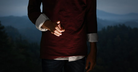 Person holding small flashlight in dark forest, illuminating path ahead. Adventure, exploration, hiking, night, wilderness, campingの写真素材