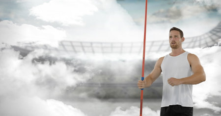 Athlete holding javelin in stadium, preparing for throw with determination. Sports, athletics, competition, track and field, performanceの写真素材