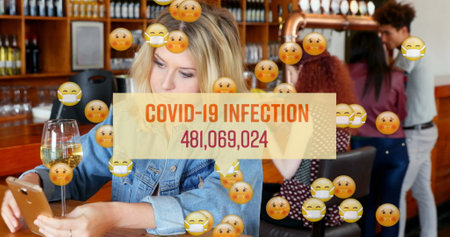 Using smartphone in bar, woman surrounded by virus emojis. Technology, social distancing, communication, nightlife, safety, healthの写真素材