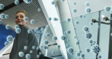 Woman on escalator surrounded by digital virus graphics, looking concerned. Pandemic, health, safety, protection, anxiety, infectionの写真素材