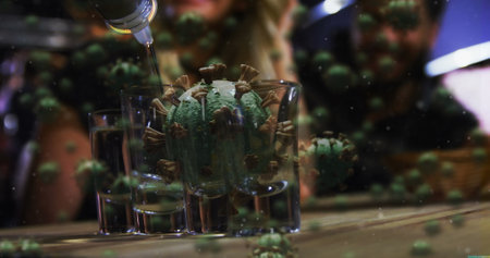 Virus model in glass with liquid pouring, symbolizing pandemic impact on lifestyle. symbolic, health, crisis, metaphor, hazard, cautionの写真素材