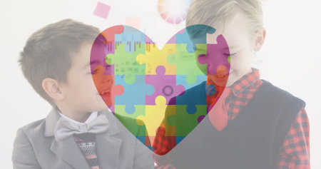 Two boys in school smiling and interacting with colorful puzzle heart overlay. Children, friendship,...