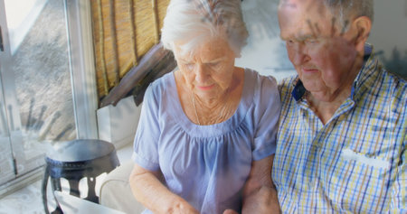 Elderly couple using laptop at home, focusing on online communication. Technology, internetの写真素材