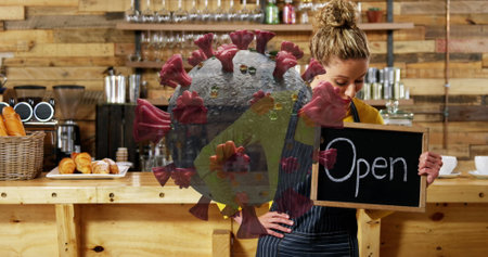 Cafe worker holding Open sign, preparing for customers during pandemic. Small business, retail,...