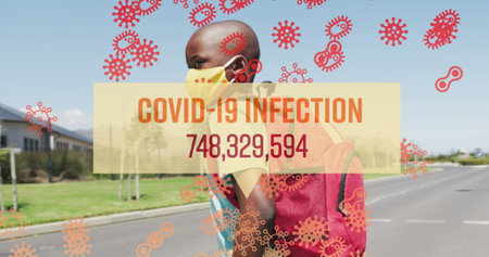 Image of words covid 19 infection rising and cells with masked boy walking to school. healthcare,...