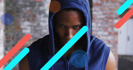Digital composite image of abstract shapes moving against portrait of african american man. sports...