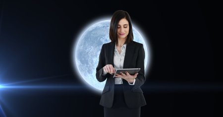 Image of woman using tablet over planet earth with glowing spot of light. astronomy, science and technology concept digitally generated image.の写真素材