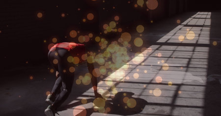 Orange spots of lights against rear view of african american woman in start position ready to run....