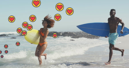 Image of heart digital icons over couple running with surfboards on beach. digital interface, social...