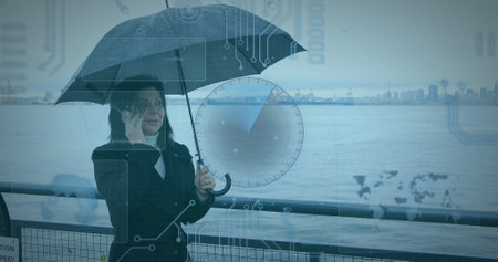 Image of data processing over woman using smartphone carrying umbrella in background. digital interface, global connection and communication concept digitally generated image.の写真素材