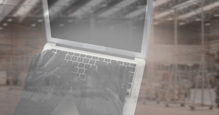 Image of person in gloves using laptop with stacks of boxes in warehouse. global shipping, online security and technology concept digitally generated image.の写真素材