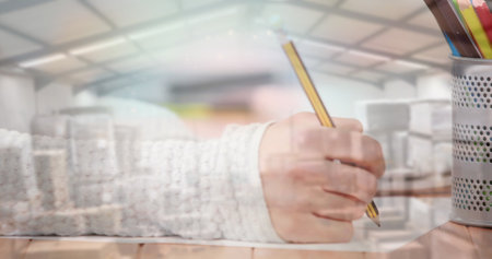 Image of woman using computer keyboard and writing with stacks of boxes in warehouse. global shipping and technology concept digitally generated image.の写真素材