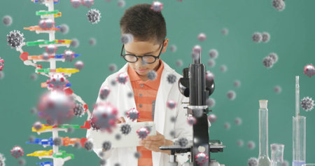 In school, young boy in lab coat studying with tablet and microscope. Education, science,...