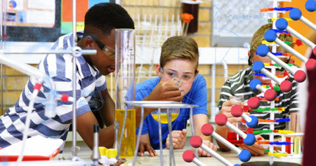Conducting science experiment with test tubes, students in school focused and engaged. Laboratory,...