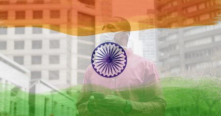 Composition of man wearing face mask in street over indian flag. global coronavirus pandemic and indian healthcare crisis concept digitally generated image.の写真素材