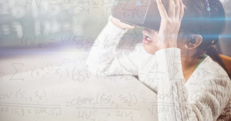 Image of mathematical equations over schoolgirl wearing vr goggles. school, education and study...