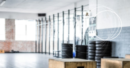 Image of white circles spinning over industrial gym interiors. fitness, active lifestyle concept digitally generated image.の写真素材