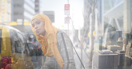 Image of asian woman in hijab catching taxi over cityscape. out and about in the city, digitally generated image.の写真素材