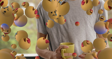 Holding yellow mug, person surrounded by floating emoji faces showing emotions. Emoticons, virtual, technology, digital, communication, connectionの写真素材