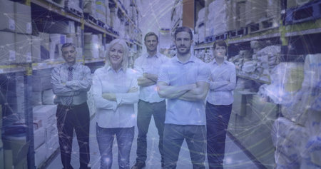 Standing confidently in warehouse, team embracing digital transformation among shelves. Teamwork, collaboration, technology, innovation, logistics, inventoryの写真素材