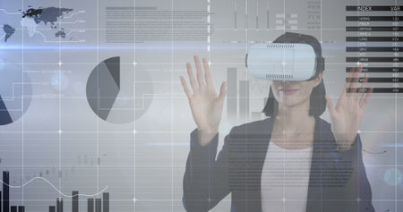 Wearing VR headset, woman interacting with virtual data and graphs over image. Technology,...