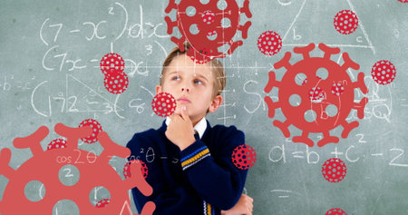 Image of Covid 19 coronavirus cells spreading over thinking schoolboy in class with chalkboard in...