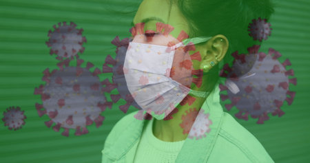 Asian woman wearing mask, virus graphics overlay, focusing on health safety. Pandemic, protection, precaution, healthcare, illnessの写真素材