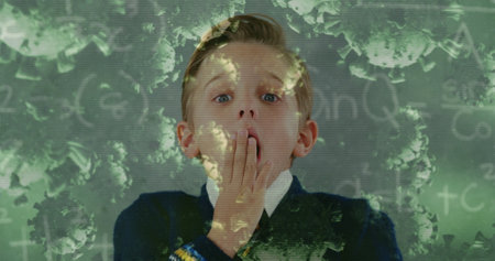 Image of Covid 19 coronavirus cells spreading over surprised schoolboy in class with chalkboard in the background. Education back to school coronavirus pandemic concept digitally generated image.の写真素材