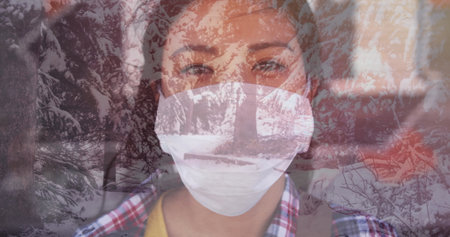 Image of woman wearing face mask against winter scenery. sickness and christmas during coronavirus...