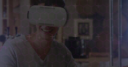 Hexagonal shapes and data processing against caucasian man wearing vr headset using digital tablet....