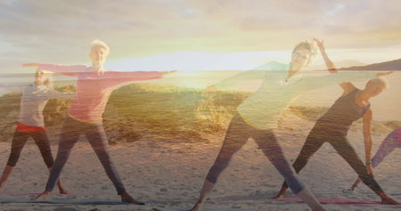 Image of glowing light over portrait of happy senior women exercising by seaside. retirement and senior life concept digitally generated image.の写真素材