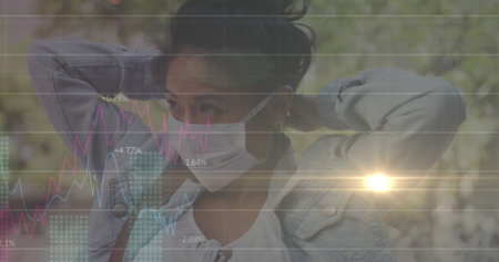 Image of data processing over woman wearing face mask. global covid 19 pandemic concept digitally...